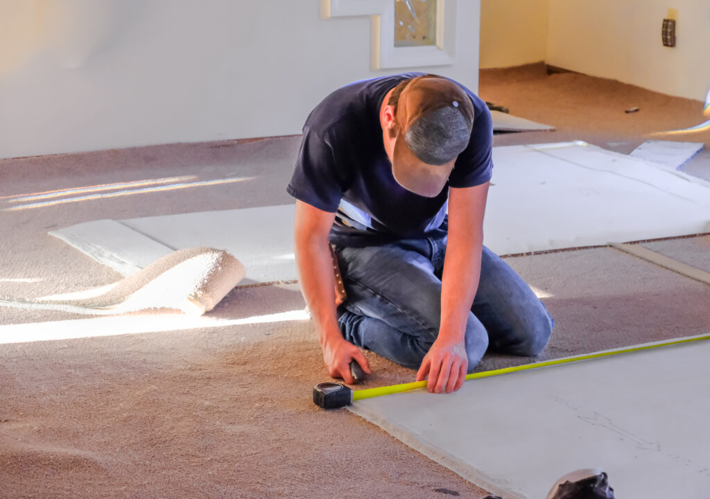 young,man,carpenter,measuring,new,rugs,he's,going,to,install