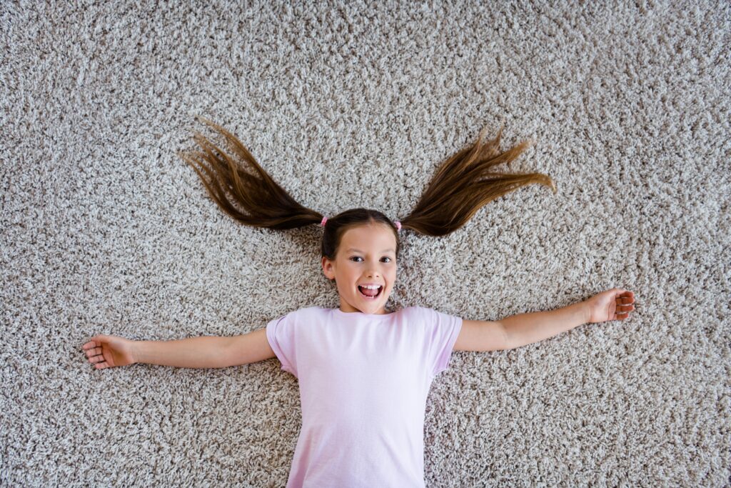 above,view,portrait,of,overjoyed,peaceful,schoolkid,lying,comfy,carpet